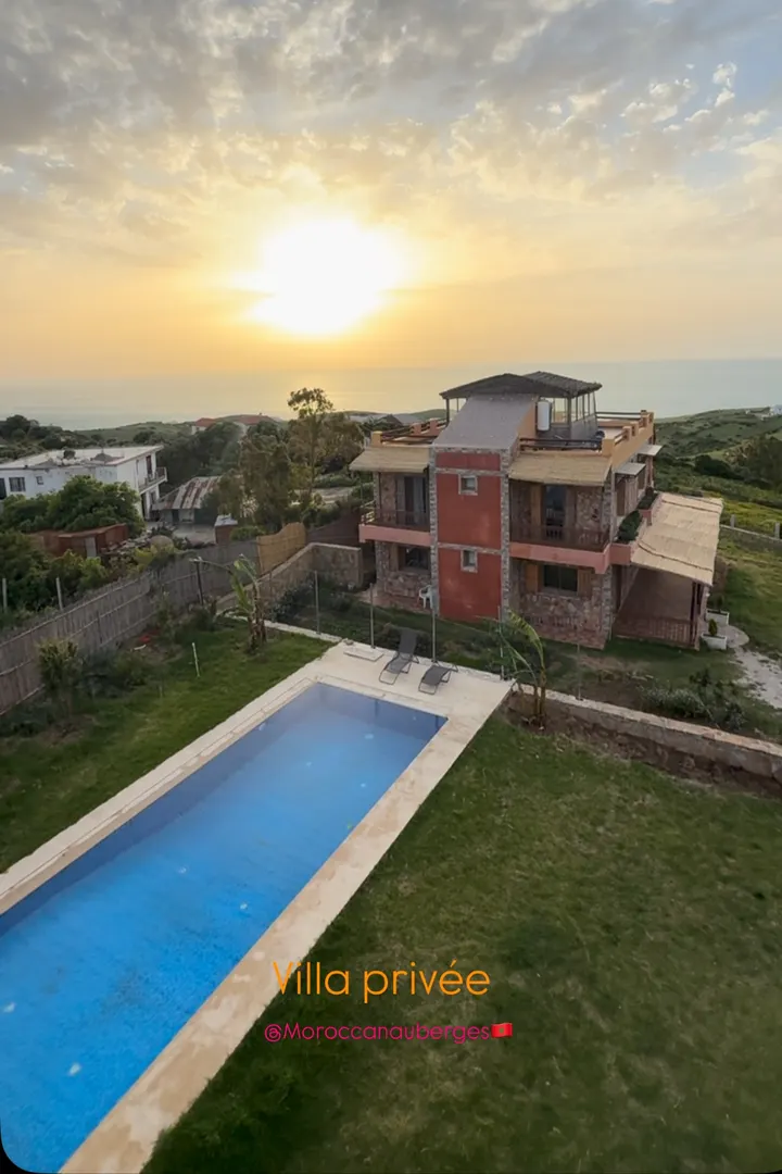 Villa with a long pool and a rooftop terrace at sunset