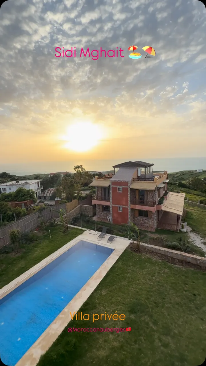 Villa avec piscine allongée et terrasse en toiture au coucher du soleil