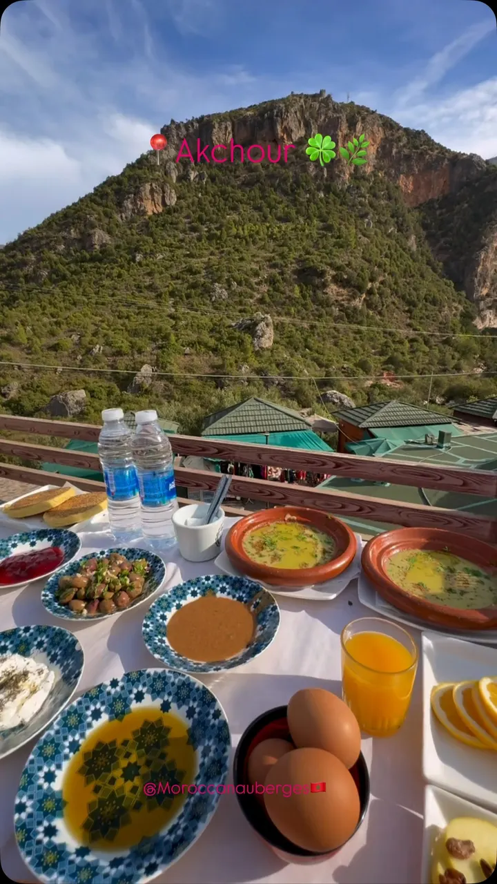 Petit-déjeuner marocain dressé sur une terrasse face à la montagne