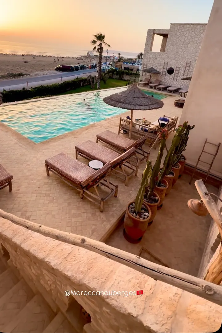 Stone terrace overlooking the pool and the beach at sunset