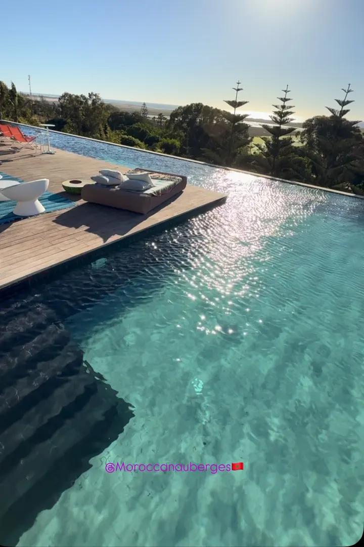 Infinity pool and wooden deck at sunset