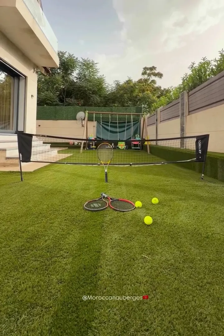 Garden with a tennis court and a children’s play area