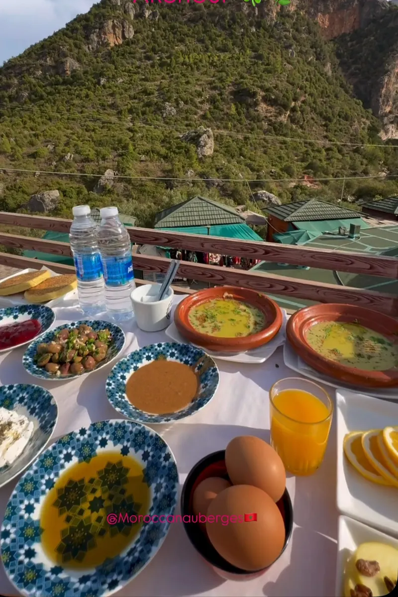 Petit-déjeuner marocain dressé sur une terrasse face à la montagne
